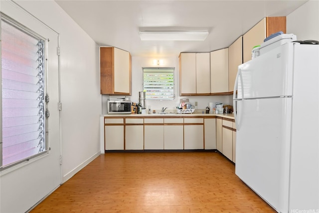854 Hao St, Honolulu, HI 96821 - kitchen featuring a sink, light wood-style floors, light countertops, freestanding refrigerator, and stainless steel microwave