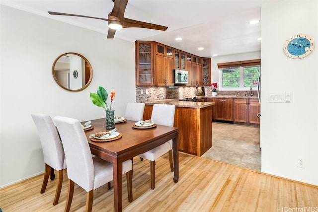 dining space with ornamental molding, ceiling fan, light hardwood / wood-style flooring, and sink