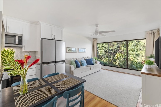 living room with light hardwood / wood-style flooring and ceiling fan