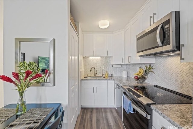 kitchen with sink, white cabinetry, light stone counters, dark hardwood / wood-style floors, and range with electric cooktop