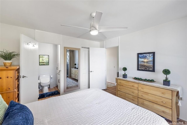 bedroom with dark wood-type flooring, ceiling fan, and connected bathroom