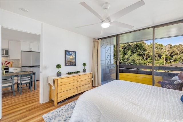 bedroom with stainless steel refrigerator, access to exterior, ceiling fan, light hardwood / wood-style floors, and floor to ceiling windows