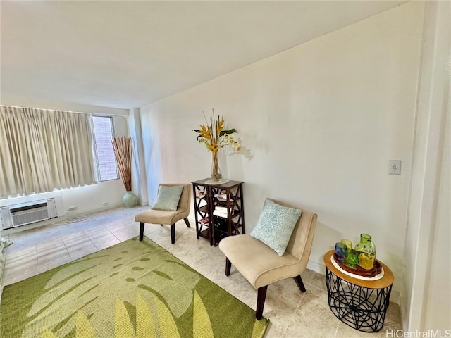 sitting room with light tile patterned flooring and an AC wall unit