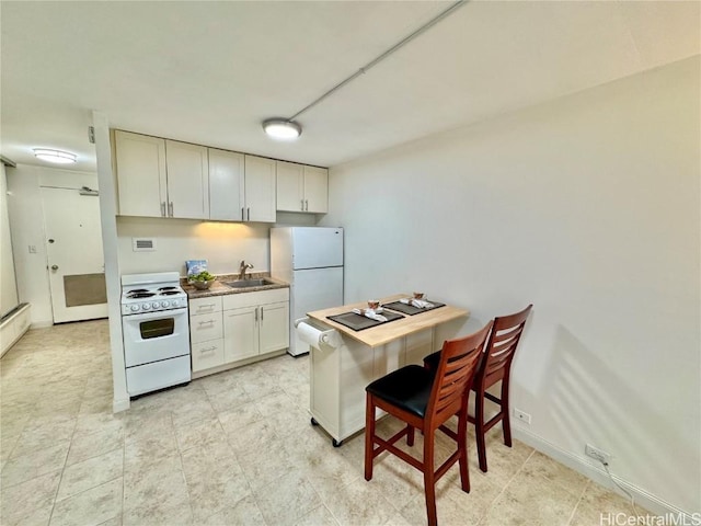 kitchen with white appliances, sink, and white cabinets