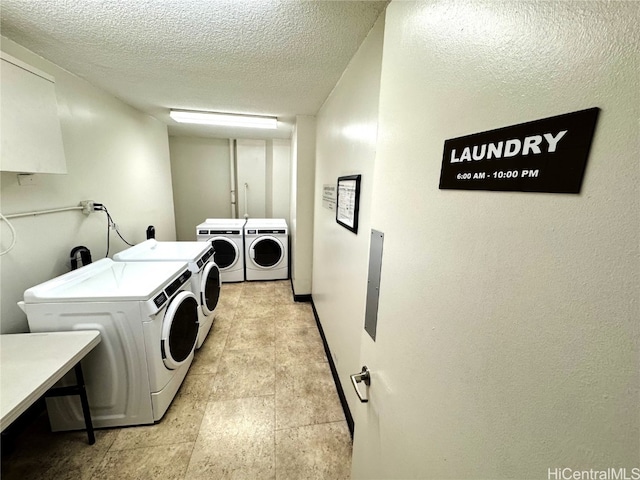 laundry room featuring separate washer and dryer and a textured ceiling