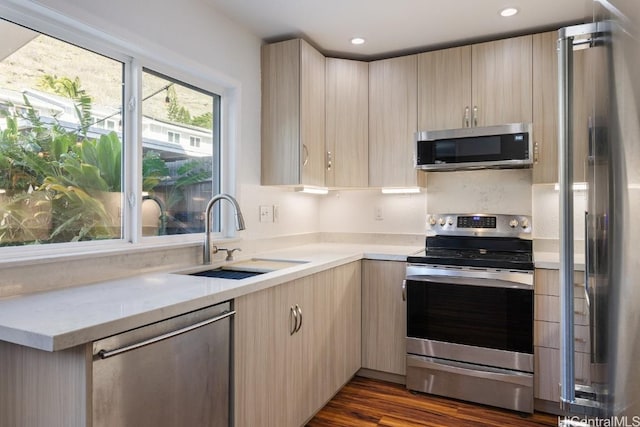 kitchen with sink, light brown cabinetry, appliances with stainless steel finishes, and dark hardwood / wood-style flooring