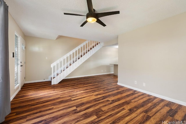 unfurnished living room featuring ceiling fan, a textured ceiling, dark hardwood / wood-style floors, and a healthy amount of sunlight