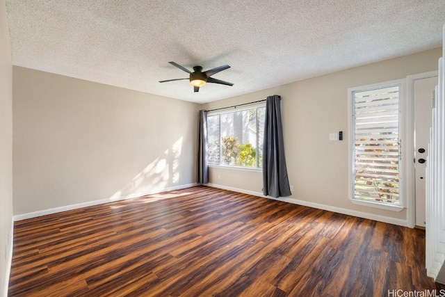 empty room featuring ceiling fan, dark wood-type flooring, and a textured ceiling