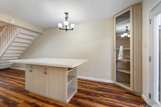 interior space featuring an inviting chandelier, a textured ceiling, and dark hardwood / wood-style floors