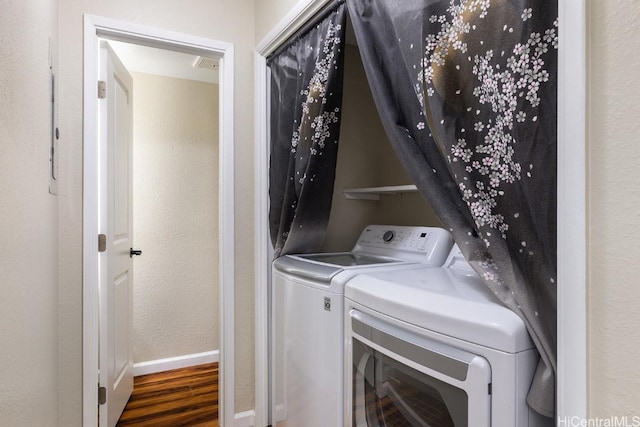 laundry area with dark wood-type flooring and washer and clothes dryer