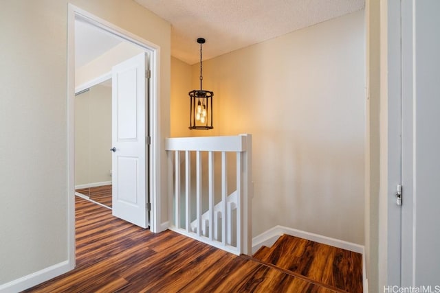 hallway featuring a textured ceiling and dark hardwood / wood-style floors