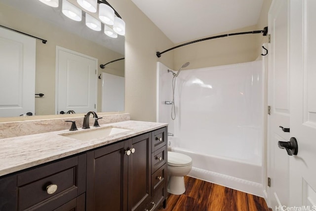 full bathroom featuring hardwood / wood-style floors, toilet,  shower combination, and vanity