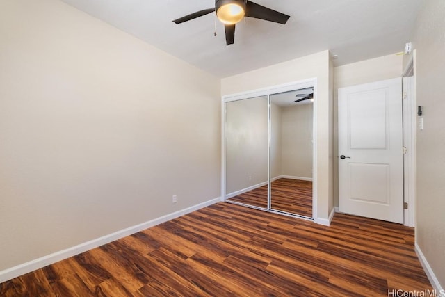 unfurnished bedroom featuring ceiling fan, dark wood-type flooring, and a closet