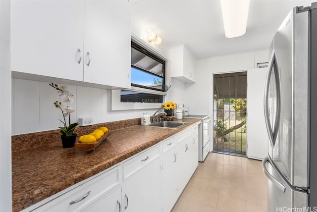 kitchen featuring white cabinets, plenty of natural light, and stainless steel refrigerator