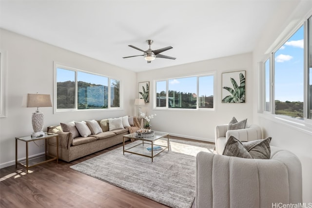 living room with dark hardwood / wood-style flooring, ceiling fan, and a healthy amount of sunlight