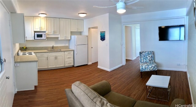 kitchen with sink, white appliances, ceiling fan, white cabinetry, and dark hardwood / wood-style flooring