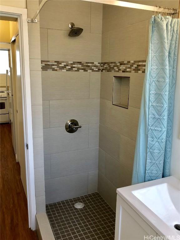 bathroom with hardwood / wood-style floors and a shower with shower curtain