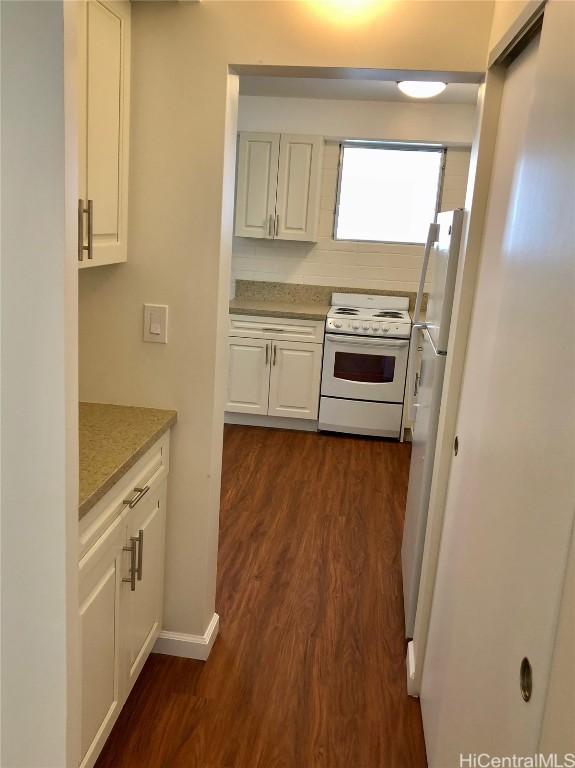 kitchen featuring white cabinetry, dark hardwood / wood-style flooring, white appliances, and decorative backsplash