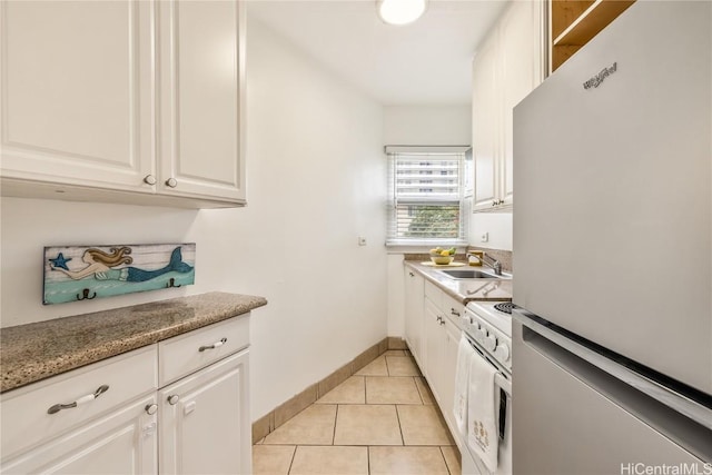 kitchen featuring white appliances, light tile patterned floors, white cabinets, sink, and light stone counters