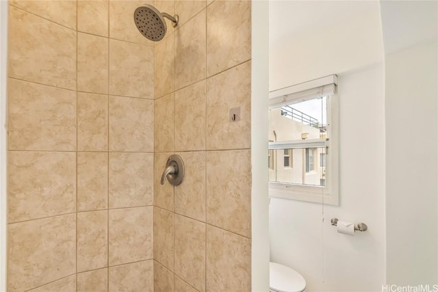 bathroom with tiled shower and toilet