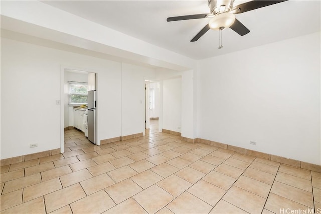 tiled spare room with ceiling fan