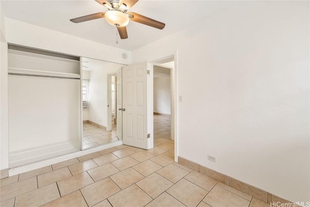 unfurnished bedroom featuring ceiling fan, light tile patterned floors, and a closet