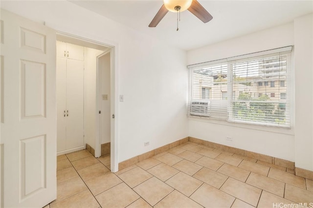 tiled empty room with ceiling fan and a wealth of natural light