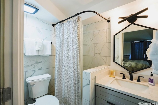 bathroom with vanity, toilet, curtained shower, and tile walls