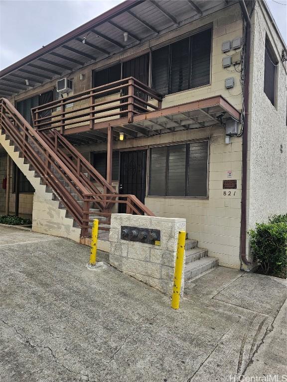 exterior space featuring a balcony and an AC wall unit