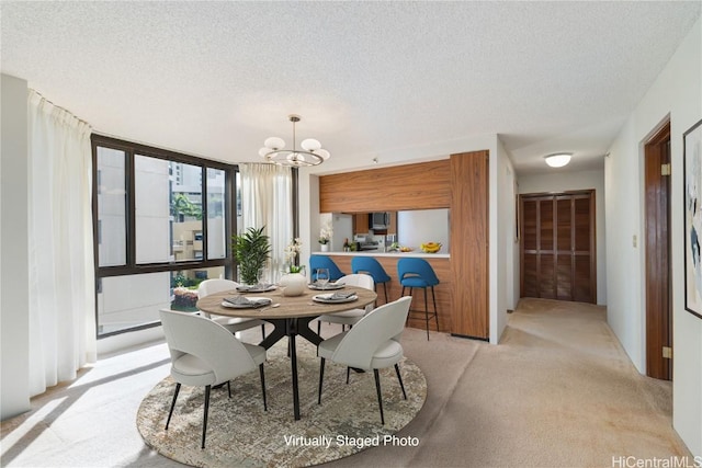 dining space featuring light carpet, a notable chandelier, a textured ceiling, and a wall of windows