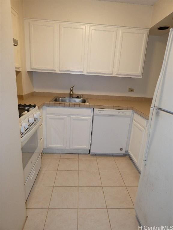 kitchen with white cabinetry, sink, light tile patterned flooring, and white appliances