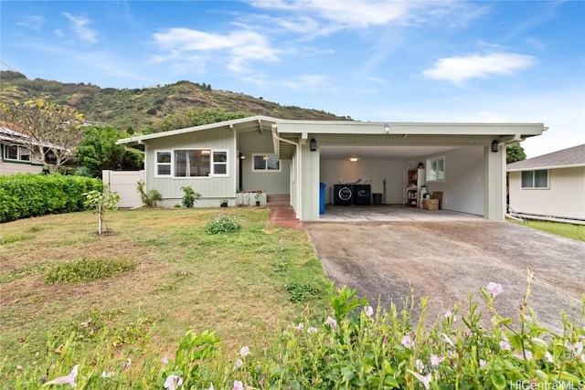 view of front facade featuring a carport, a mountain view, and a front lawn