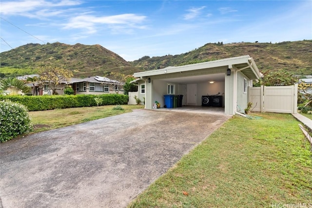 view of side of home featuring a carport, a mountain view, and a lawn