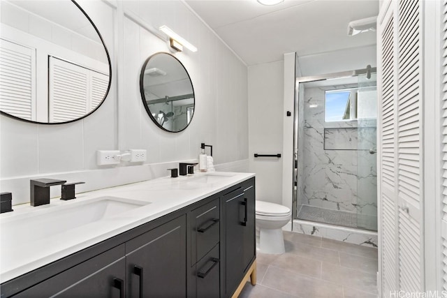 bathroom featuring tile patterned flooring, vanity, toilet, and walk in shower