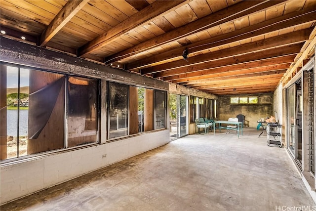 interior space featuring beamed ceiling, a water view, a wealth of natural light, and wooden ceiling