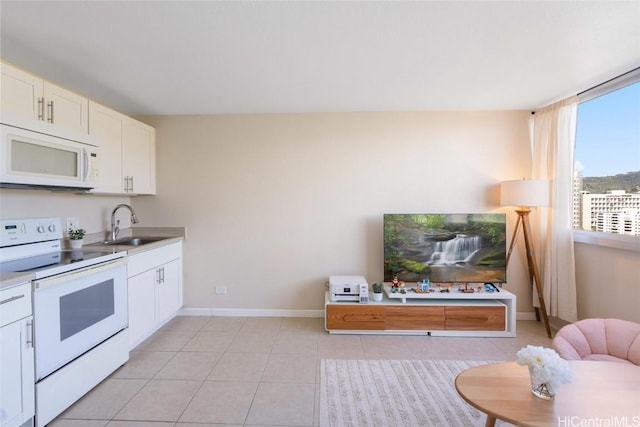 kitchen featuring light tile patterned floors, white appliances, white cabinets, and sink