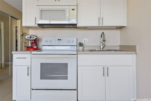 kitchen with white cabinetry, sink, white appliances, and light tile patterned floors