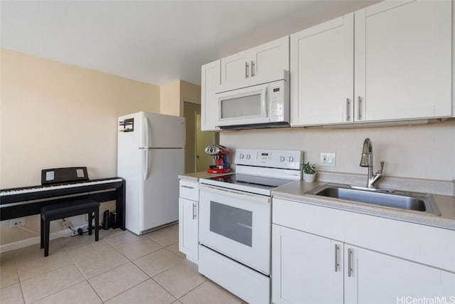 kitchen with sink, white appliances, white cabinets, and light tile patterned floors