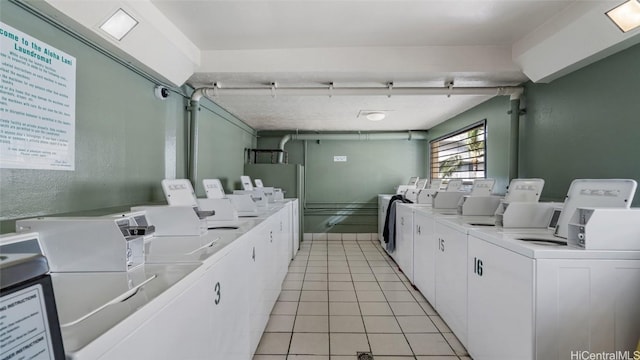 washroom featuring washer and clothes dryer and light tile patterned floors