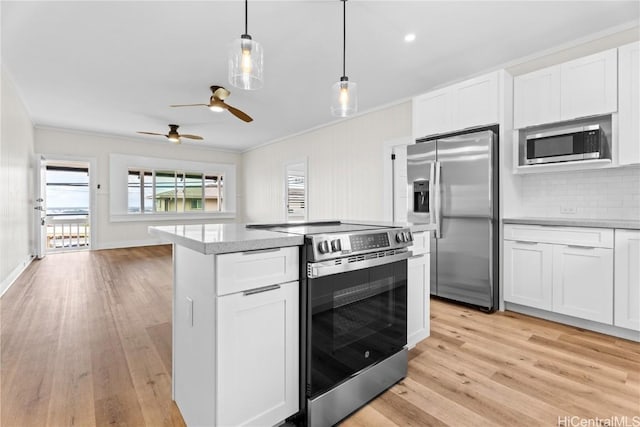 kitchen with crown molding, pendant lighting, white cabinets, light wood-type flooring, and stainless steel appliances