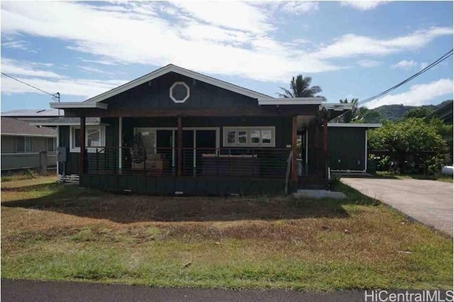 bungalow-style house with a front yard and covered porch