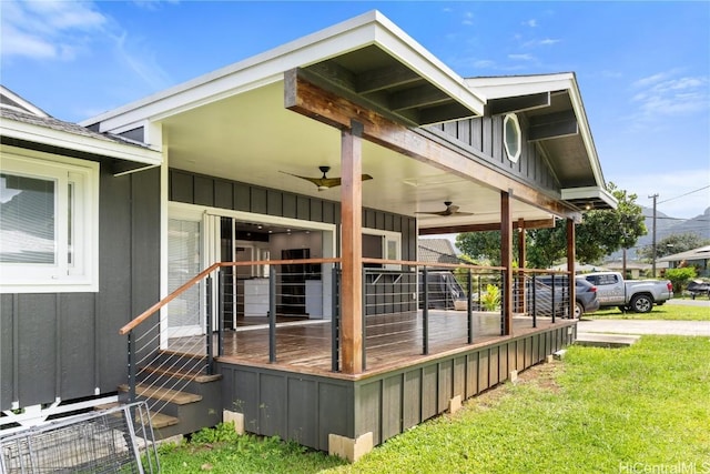 wooden terrace featuring a yard and a ceiling fan