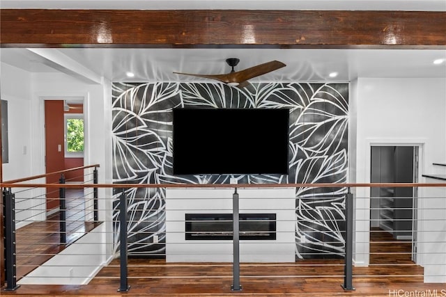 interior details with wood finished floors, beamed ceiling, recessed lighting, and a fireplace