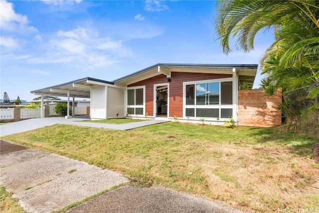 view of front of home with a front yard and a carport