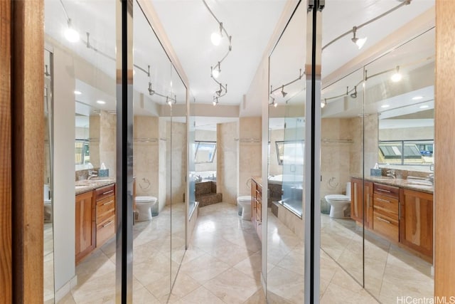 bathroom with walk in shower, vanity, and toilet