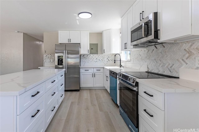 kitchen with light stone countertops, white cabinetry, and appliances with stainless steel finishes