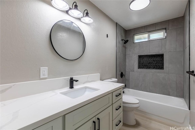 full bathroom with wood-type flooring, tiled shower / bath combo, vanity, and toilet