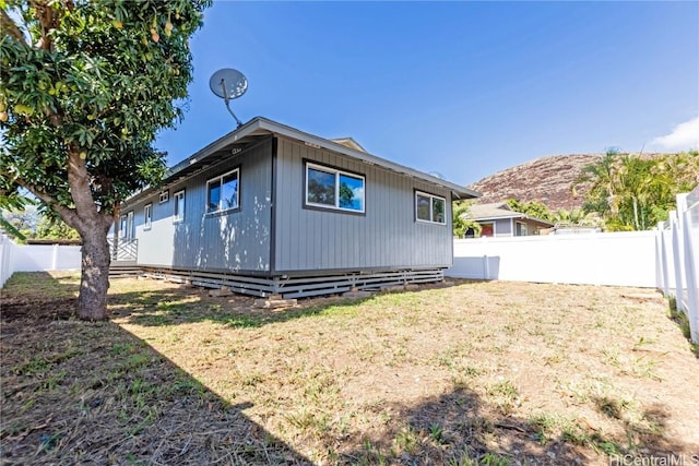 rear view of house with a mountain view and a lawn