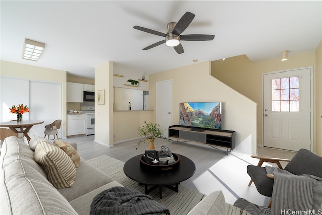 living room featuring light wood-type flooring and ceiling fan