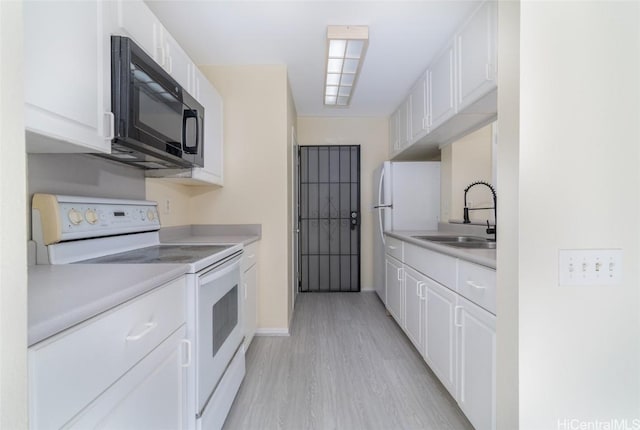 kitchen with light hardwood / wood-style floors, electric stove, white cabinets, and sink